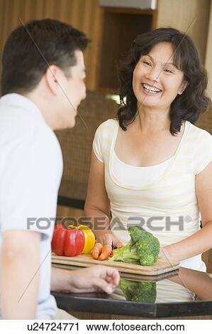 Stock Image - Husband And Wife Preparing meal, mealtime Together. Fotosearch