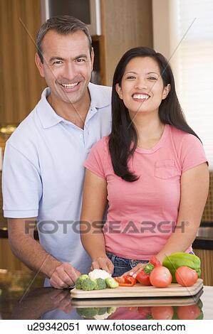 Stock Image - Husband And Wife Preparing meal, mealtime Together. Fotosearch