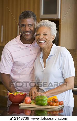 Stock Photo - Husband And Wife Preparing meal, mealtime Together. Fotosearch