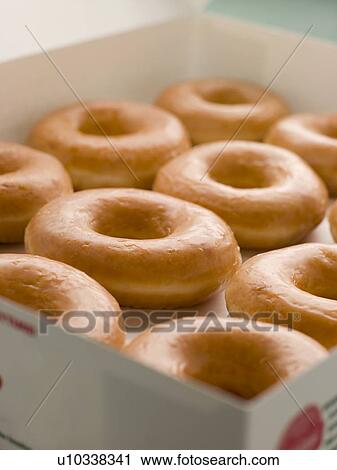 Stock Image - Iced Ring Doughnuts In A Tray. Fotosearch