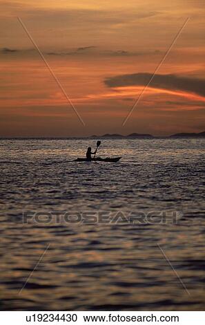Kayaker outdoors in ocean at sunset (far away/silhouette) View Large Photo Image Stock Image - Kayaker outdoors in ocean at sunset (far away/silhouette). Fotosearch