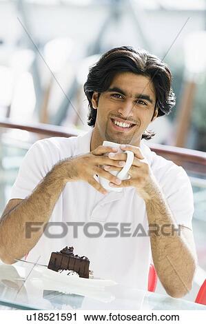 Man at restaurant eating dessert and smiling (selective focus) View Large Photo Image Stock Image - Man at restaurant eating dessert and smiling (selective focus). Fotosearch