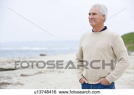 Man at the beach with hands in pockets View Large Photo Image Stock Photograph - Man at the beach with hands in pockets. Fotosearch