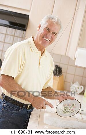 Stock Image - Man Cleaning Dishes . Fotosearch