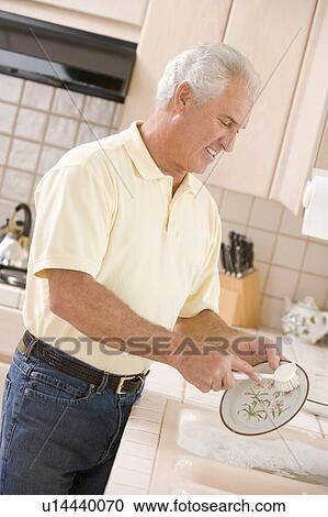 Stock Image - Man Cleaning Dishes . Fotosearch