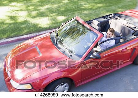 Man driving convertible car smiling View Large Photo Image Stock Photo - Man driving convertible car smiling. Fotosearch