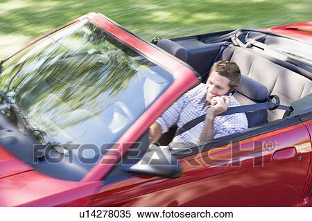 Man driving convertible car using cellular phone and smiling View Large Photo Image Stock Photography - Man driving convertible car using cellular phone and smiling. Fotosearch