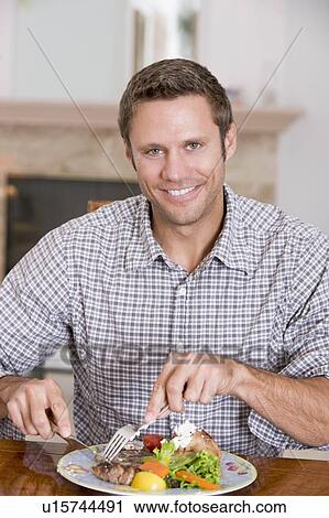 Stock Image - Man Eating Healthy meal, mealtime Together. Fotosearch