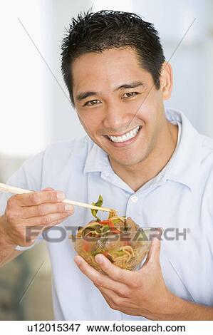 Stock Photo - Man Enjoying Chinese Food With Chopsticks. Fotosearch