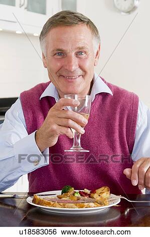 Stock Photograph - Man Enjoying Healthy meal, mealtime With A Glass Of Wine. Fotosearch