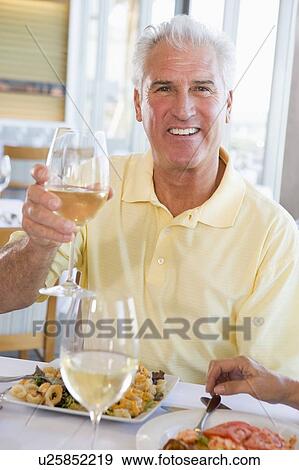 Man Enjoying meal, mealtime With A Glass Of Wine View Large Photo Image Stock Photo - Man Enjoying meal, mealtime With A Glass Of Wine . Fotosearch