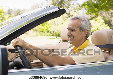 Man in convertible car smiling View Large Photo Image Stock Photograph - Man in convertible car smiling. Fotosearch