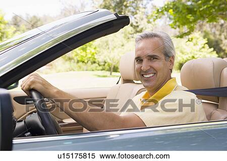 Man in convertible car smiling View Large Photo Image Stock Photography - Man in convertible car smiling. Fotosearch