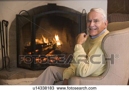 Stock Image - Man in living room smiling. Fotosearch