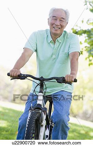 Man on bike outdoors smiling View Large Photo Image Stock Image - Man on bike outdoors smiling. Fotosearch