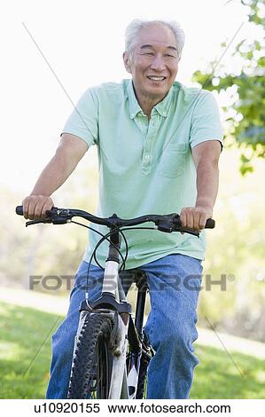 Man on bike outdoors smiling View Large Photo Image Stock Photography - Man on bike outdoors smiling. Fotosearch