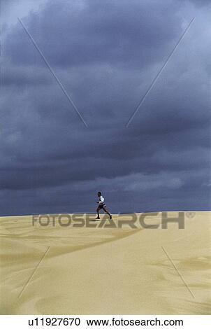 Man outdoors running in the desert (far away) View Large Photo Image Stock Image - Man outdoors running in the desert (far away). Fotosearch