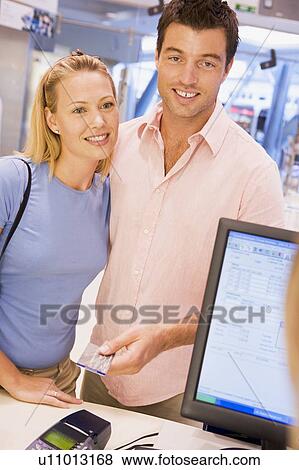 Stock Photo - Man paying for purchases with credit card. Fotosearch