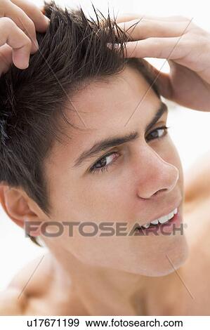 Stock Photo - Man playing with hair smiling. Fotosearch