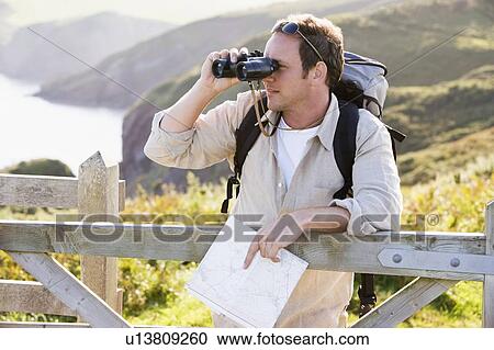 Man relaxing on cliffside path holding map and binoculars View Large Photo Image Stock Image - Man relaxing on cliffside path holding map and binoculars. Fotosearch