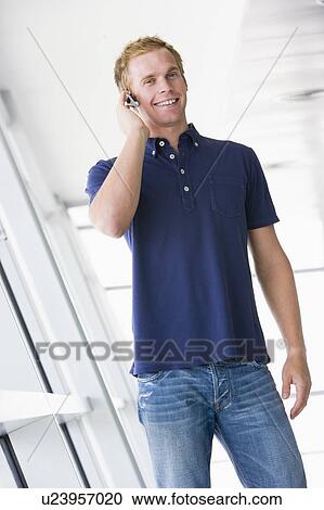 Man standing in corridor wearing headset smiling View Large Photo Image Stock Image - Man standing in corridor wearing headset smiling. Fotosearch