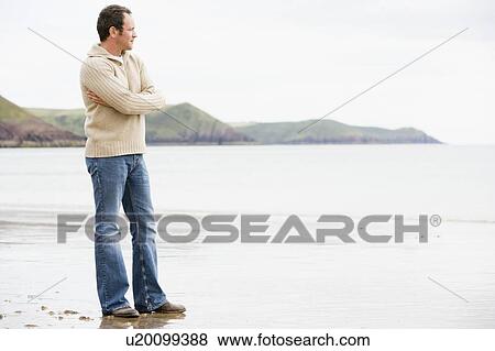 Stock Photo - Man standing on beach. Fotosearch