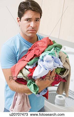 Stock Image - Man Upset Doing Laundry. Fotosearch