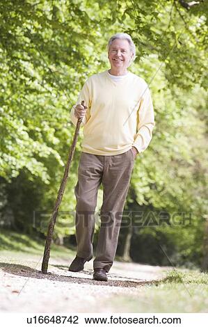 Stock Image - Man walking outdoors smiling. Fotosearch