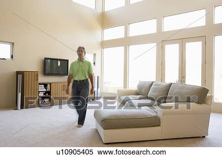 Stock Photography - Man walking through living room. Fotosearch