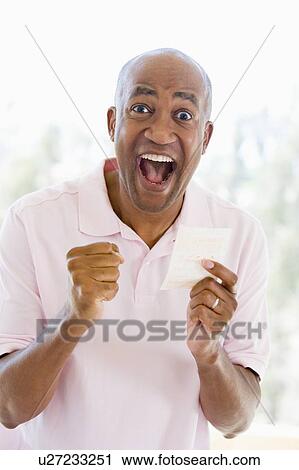 Man with winning lottery ticket excited and smiling View Large Photo Image Stock Image - Man with winning lottery ticket excited and smiling. Fotosearch