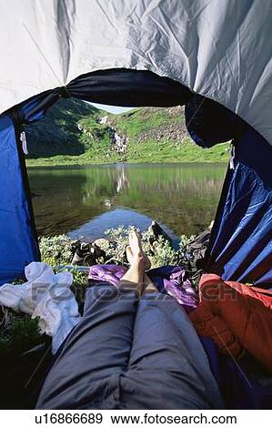 Man's legs in a tent overlooking scenic location View Large Photo Image Stock Photo - Man's legs in a tent overlooking scenic location. Fotosearch