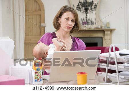 Mother and baby in home office with laptop View Large Photo Image Stock Photo - Mother and baby in home office with laptop. Fotosearch