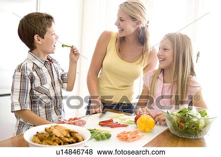Stock Photo - Mother And Children Prepare A meal, mealtime Together . Fotosearch