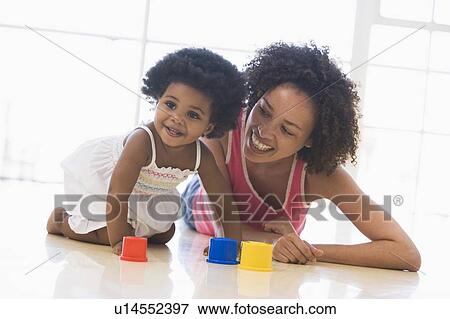 Mother and daughter indoors playing and smiling View Large Photo Image Stock Photo - Mother and daughter indoors playing and smiling. Fotosearch