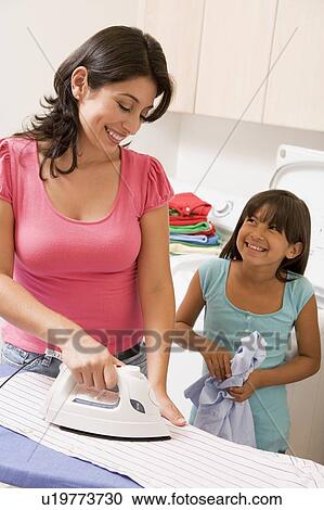 Stock Image - Mother And Daughter Ironing . Fotosearch