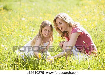 Mother and daughter outdoors holding flower smiling View Large Photo Image Stock Photo - Mother and daughter outdoors holding flower smiling. Fotosearch