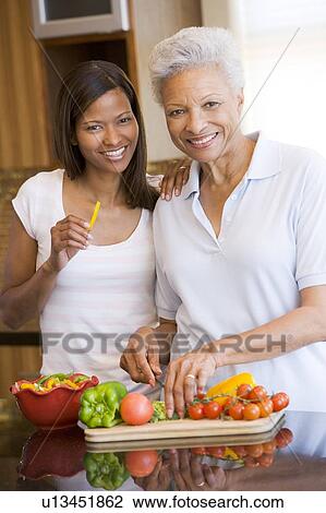 Stock Image - Mother And Daughter Preparing meal, mealtime Together. Fotosearch