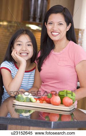 Stock Photography - Mother And Daughter Preparing meal, mealtime Together . Fotosearch