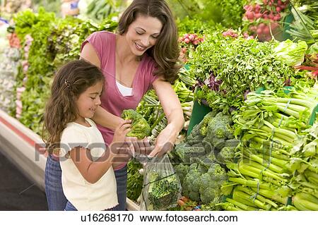 Mother and daughter shopping for broccoli at a grocery store View Large Photo Image Stock Image - Mother and daughter shopping for broccoli at a grocery store. Fotosearch