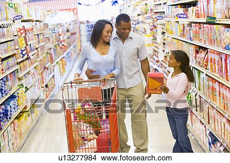 Picture - Mother and father with young daughter shopping at the grocery store.. Fotosearch