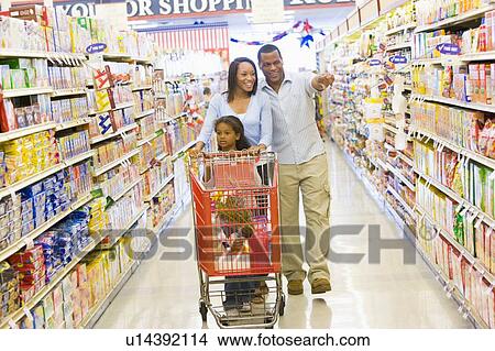 Mother and father with young daughter shopping at the grocery store. View Large Photo Image Picture - Mother and father with young daughter shopping at the grocery store.. Fotosearch