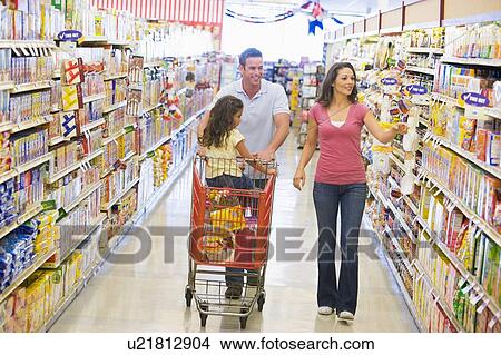 Picture - Mother and father with young daughter shopping for a new car. Fotosearch