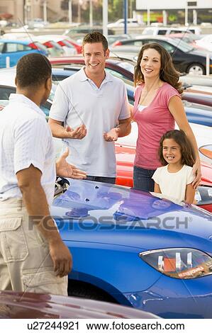 Mother and father with young daughter shopping for a new car View Large Photo Image Stock Image - Mother and father with young daughter shopping for a new car. Fotosearch