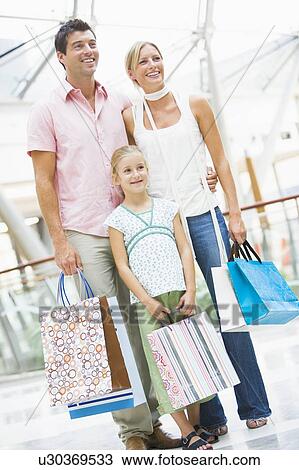Mother and father with young daughter at a shopping mall View Large Photo Image Stock Image - Mother and father with young daughter at a shopping mall. Fotosearch