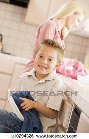 Stock Photograph - Mother And Son Cleaning Dishes. Fotosearch