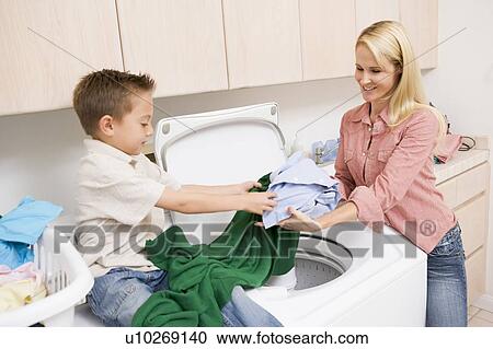 Stock Image - Mother And Son Doing Laundry . Fotosearch