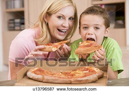 Stock Photo - Mother And Son Eating Pizza Together. Fotosearch