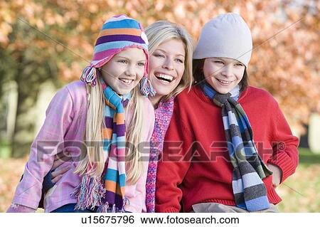 Mother and two young children outdoors at park smiling (selective focus) View Large Photo Image Stock Photograph - Mother and two young children outdoors at park smiling (selective focus). Fotosearch