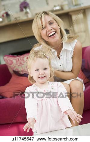 Mother in living room with baby smiling View Large Photo Image Stock Photo - Mother in living room with baby smiling. Fotosearch
