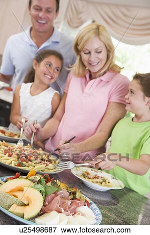 Mother Serving Up Dinner For Family View Large Photo Image Stock Photo - Mother Serving Up Dinner For Family. Fotosearch